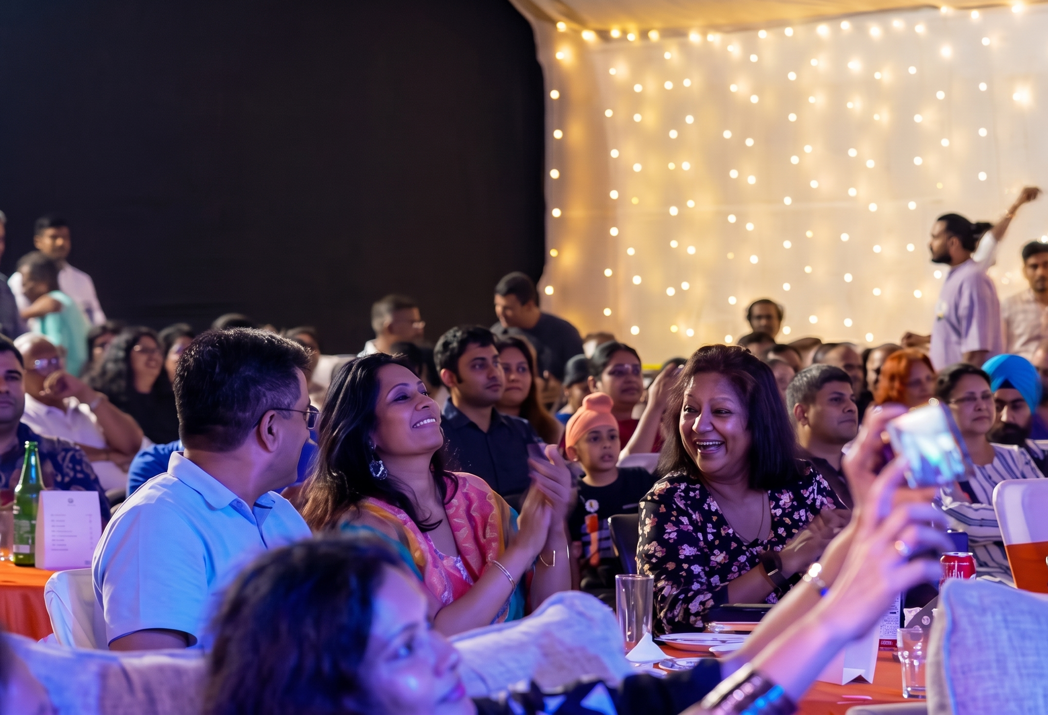 Audience gathered in a live room with warm stage lighting