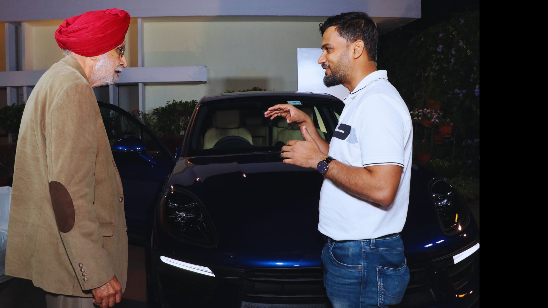 Guest conversation beside a premium car at a venue