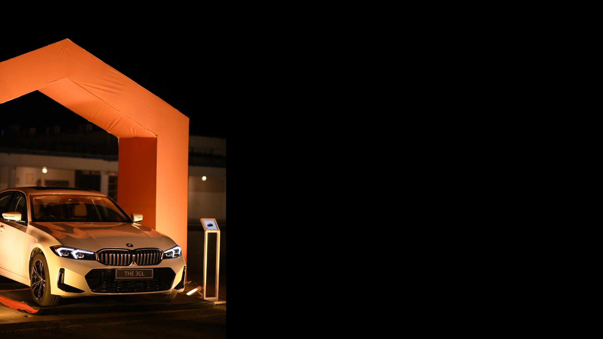 BMW staged under an orange event structure at night