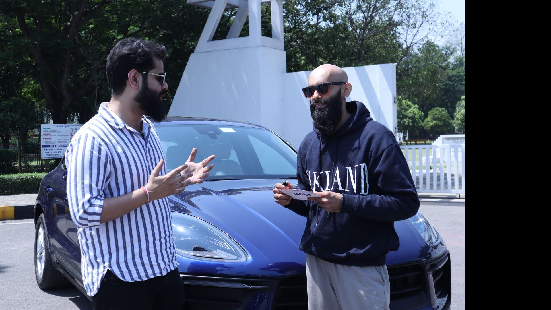 Two people talking beside a car